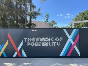 A construction wall in EPCOT with the phrase "The Magic of Possibility" written on the side